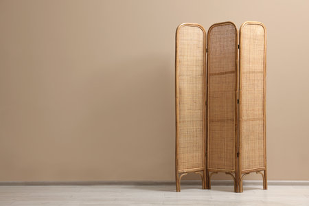 One folding screen near beige wall indoors, space for textの写真素材