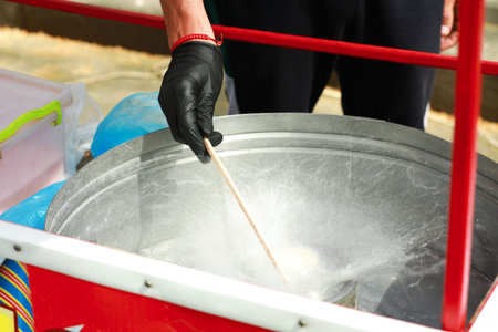 Man making cotton candy with machine outdoors, closeupの写真素材