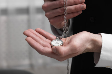 Man holding chain with elegant pocket watch, closeup. Space for textの写真素材
