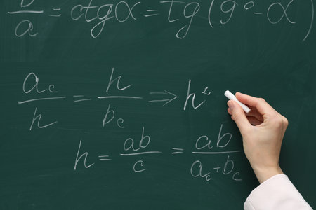 Teacher writing down math equation on green board, closeupの写真素材