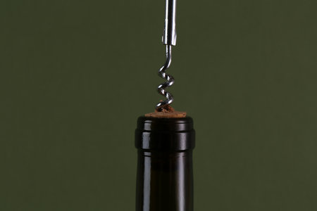 Wine bottle with corkscrew on olive background, closeupの写真素材