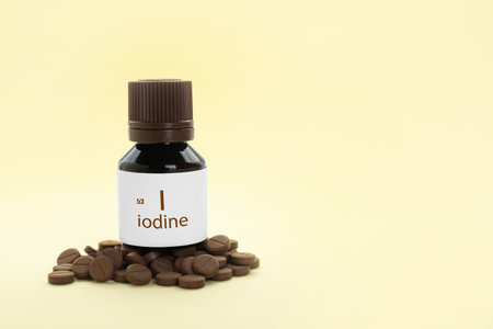Bottle and iodine pills on beige background. Space for textの写真素材
