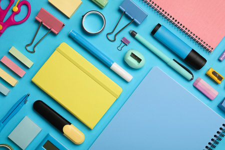 Flat lay composition with notebook and different stationery on light blue backgroundの写真素材