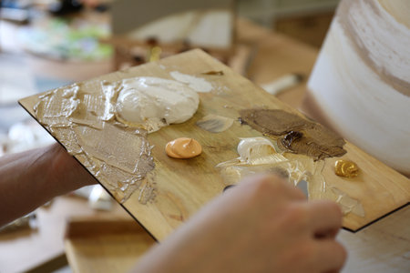 Woman with wooden palette in drawing studio, closeup