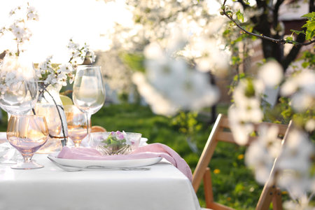 Stylish table setting with beautiful spring flowers in gardenの写真素材