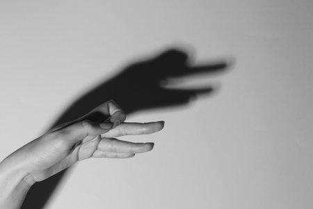 Shadow puppet. Woman making hand gesture like goose on light background, closeup with space for text. Black and white effectの写真素材