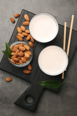 Glasses of almond milk and almonds on gray table, top viewの写真素材