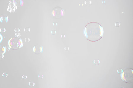 Beautiful transparent soap bubbles on gray background