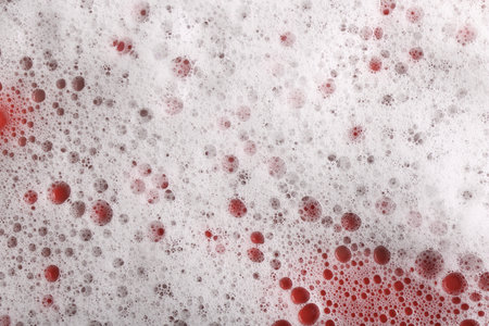 White foam with bubbles on red background, top viewの写真素材