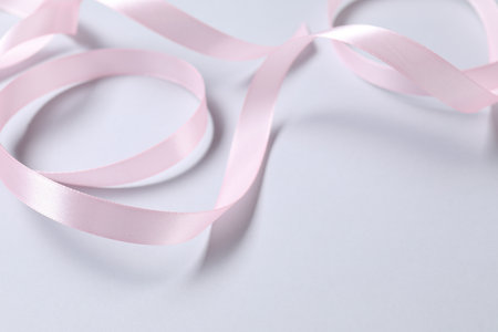 One beautiful pink ribbon on white background, space for textの写真素材