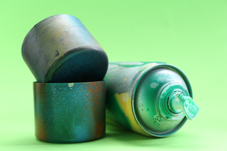 Spray paint can with caps on green background, closeupの写真素材