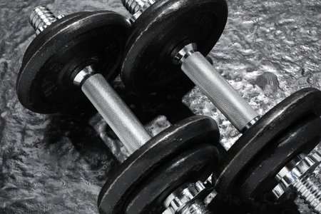 Two barbells on dark textured floor, closeupの写真素材