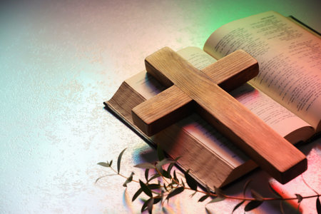 Wooden cross, Bible and eucalyptus branch on textured table in color lights, closeup with space for text. Religion of Christianityの写真素材
