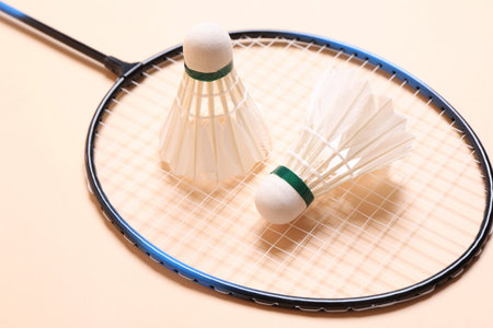 Feather badminton shuttlecocks and racket on beige background, closeupの写真素材