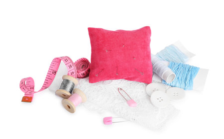 Pincushion, needles and other sewing tools isolated on whiteの写真素材
