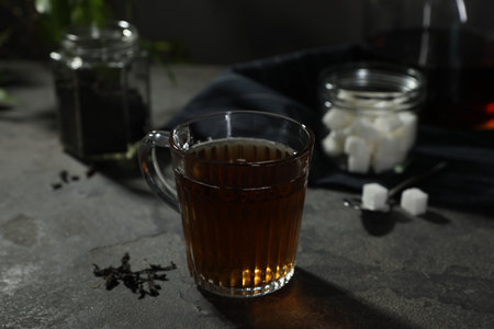 Tasty hot tea in cup on gray table, closeup