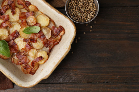 Delicious baked potatoes, bacon, basil and peppercorns on wooden table, top view. Space for textの写真素材