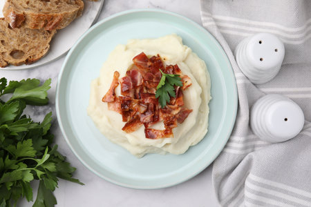 Fried bacon, mashed potato, parsley and bread on white marble table, top viewの写真素材