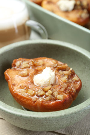Tasty baked quince with cream cheese in bowl on table, closeupの写真素材