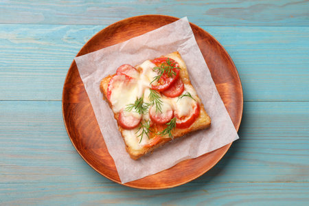 Tasty pizza toast with cheese, tomato and dill on light blue wooden table, top viewの写真素材