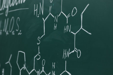 Chemical formulas written with chalk on green boardの写真素材