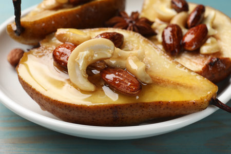 Delicious baked pears with nuts and honey on light blue wooden table, closeupの写真素材