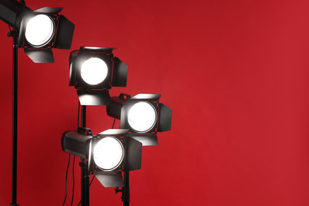 Red photo background and professional lighting equipment in studio, space for textの写真素材