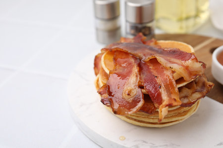 Delicious pancakes with bacon and honey on white table, closeup. Space for textの写真素材