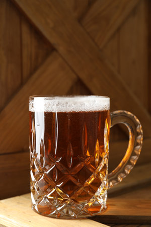 Mug with fresh beer on wooden crateの写真素材