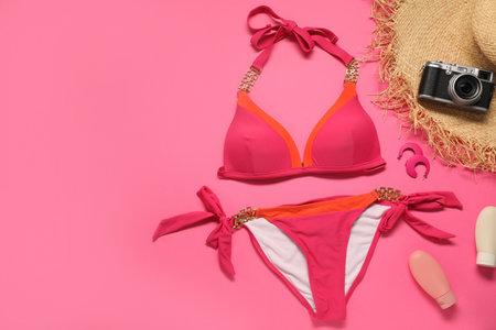 Flat lay composition with beautiful swimsuit on pink background. Space for textの写真素材