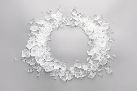 Frame of crushed ice on gray background, top view. Space for text