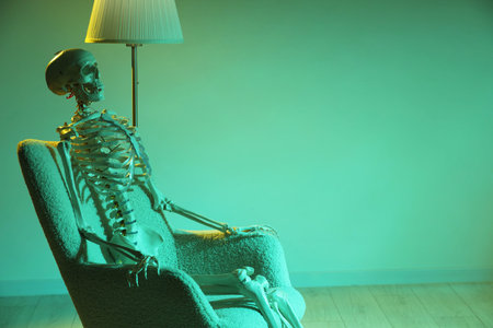 Waiting concept. Human skeleton sitting in armchair indoors, space for textの写真素材