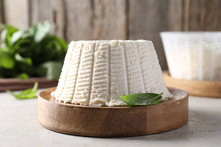 Fresh ricotta (cream cheese) and basil on light gray table, closeupの写真素材