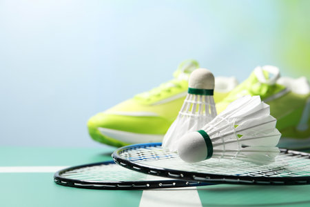 Feather badminton shuttlecocks and rackets on court, space for textの写真素材