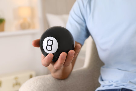 Man holding magic eight ball indoors, closeupの写真素材
