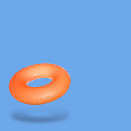 Orange inflatable ring in air on blue background. Space for textの写真素材