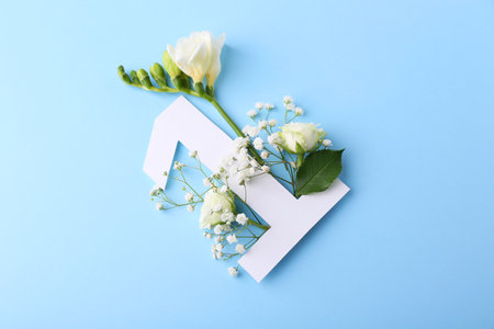 Paper number 1 and beautiful flowers on light blue background, top viewの写真素材