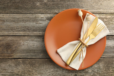 Stylish setting with cutlery and plate on wooden table, top view. Space for textの写真素材