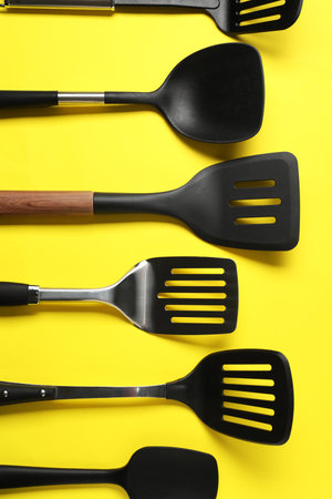 Different spatulas on yellow background, flat layの写真素材