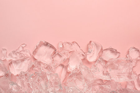 Pieces of crushed ice on pink background, top view. Space for textの写真素材