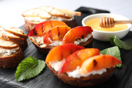 Delicious bruschettas with ricotta cheese and honey on light gray table, closeupの写真素材