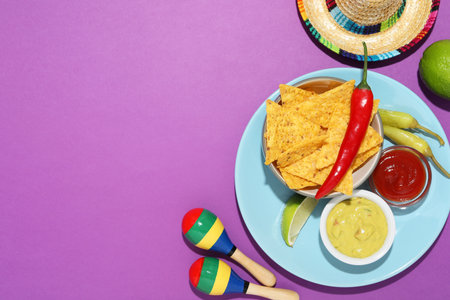 Nachos chips, guacamole, chili pepper, maracas and Mexican sombrero hat on purple background, flat...
