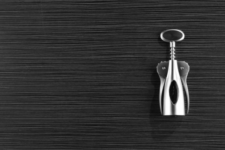One wing corkscrew on black wooden table, top view. Space for textの写真素材