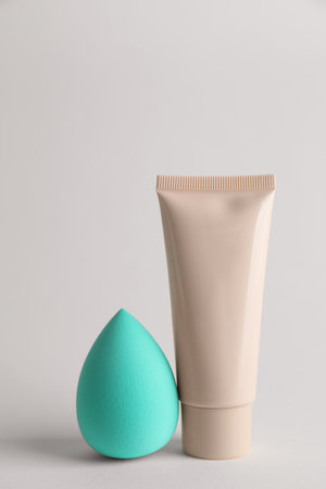 Makeup sponge and skin foundation on light gray backgroundの写真素材
