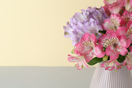 Beautiful alstroemeria flowers in vase on color background, closeup. Space for textの写真素材