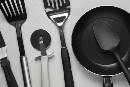 Different spatulas and other kitchen utensils on gray background, flat layの写真素材