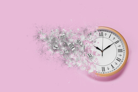 Clock shattering into pieces on pink background. Flow of timeの写真素材