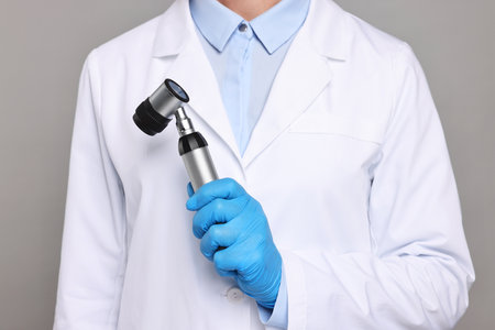 Dermatologist with dermatoscope on gray background, closeupの写真素材