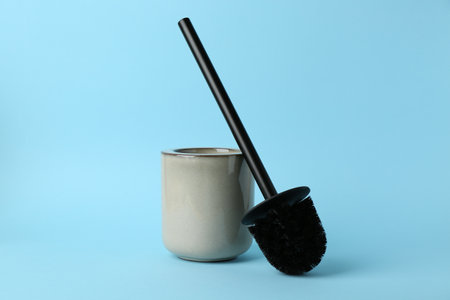 Toilet brush and holder on light blue backgroundの写真素材