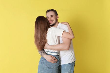 Happy couple hugging on yellow background. Strong relationshipの写真素材